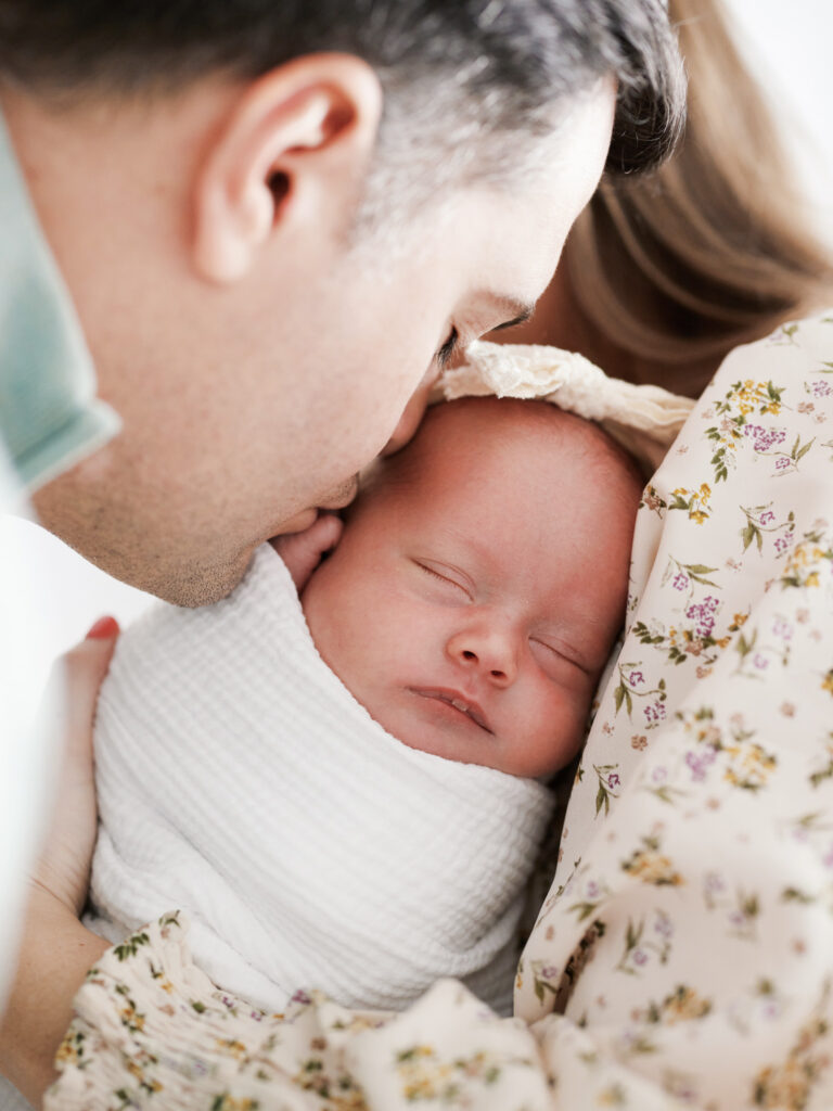 Father nuzzling cheek against sleeping newborn baby during in-home newborn session in Western Springs Illinois